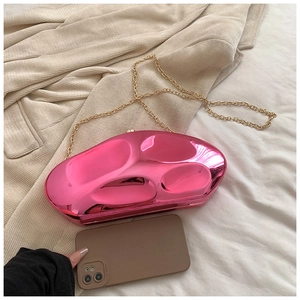 Detail of rose pink irregular metallic evening clutch bag with gold chain and glossy mirror finish