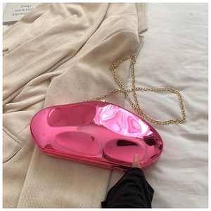 Macro detail of glossy bright pink pebble-shaped acrylic evening clutch with gold chain