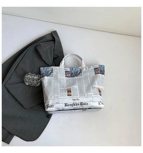 Flat lay of newspaper print tote bag showing large capacity and stylish typography