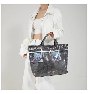 Detail of large tote bag with newspaper print pattern and glossy coating surface