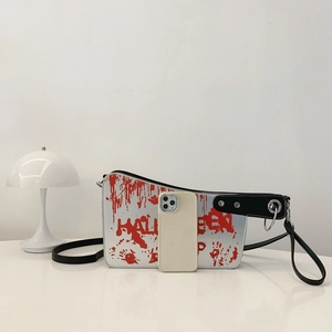 Silver Halloween kitchen knife crossbody bag with red blood spray and phone size reference
