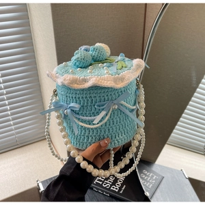 Détail d'un sac au crochet bleu en forme de gâteau avec perles et rubans élégants