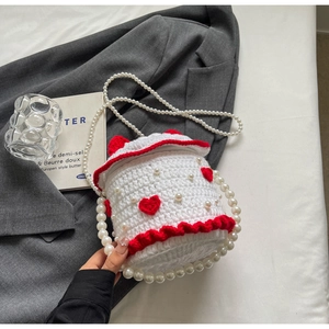 Détail du sac gâteau au crochet avec broderie cœur rouge et chaîne de perles élégante