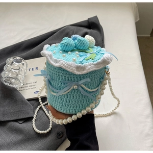 Détail du sac tricoté en gâteau bleu avec bandoulière en perles et accents de fleurs