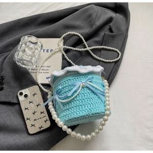 Détails du sac seau en tricot bleu clair avec rubans et bandoulière chaîne en perles