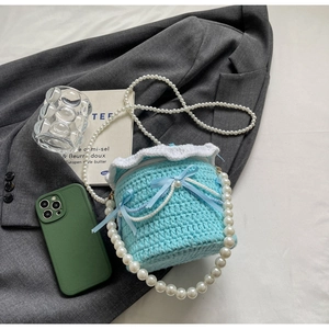 Détail du sac à gâteau au crochet bleu avec dentelle et bandoulière en perles