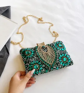 Detailed close-up of emerald green rhinestone evening bag with intricate crystal flower pattern