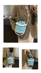 Détail du sac tricoté bleu clair avec chaîne de perles et nœud en ruban élégant