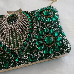 Close-up of luxury evening bag featuring emerald rhinestones and floral patterns