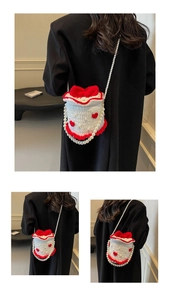 Détail du sac tricoté en forme de gâteau avec nœud rouge, cœurs et chaîne en perles