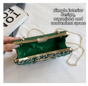 Detail view of the green rhinestone evening bag interior with gold chain strap