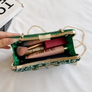 Detail view of emerald green rhinestone evening bag showing interior storage capacity