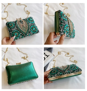 Detail of emerald green evening clutch bag featuring intricate floral rhinestone patterns