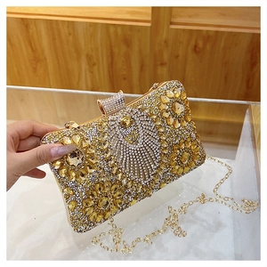 Detailed macro view of golden evening clutch bag featuring floral rhinestone patterns