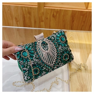 Detail of emerald green evening clutch with sparkling rhinestones and gold chain