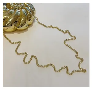 Détail du sac de soirée doré en forme de coquillage avec texture métallique et chaîne