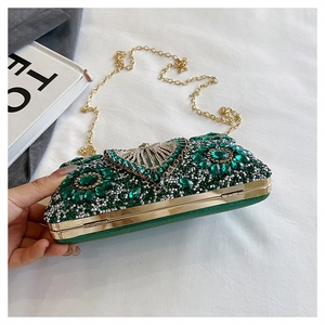 Macro view of emerald green evening clutch with sparkling rhinestones and gold chain