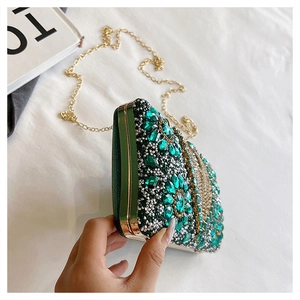 Detail of emerald green rhinestone evening bag with luxury gold chain and frame