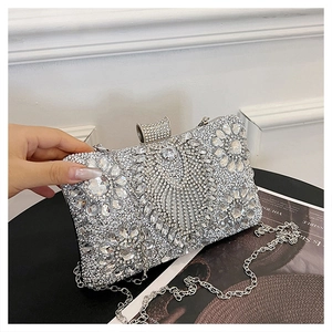 Close-up of sparkling silver rhinestone clutch with large crystals and metal chain