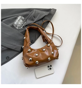 Vue détaillée d'un sac bandoulière marron plissé avec des rivets métalliques