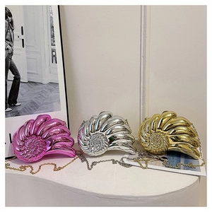 Détail de trois sacs de soirée en forme de coquillage métallisé rose, or et argent