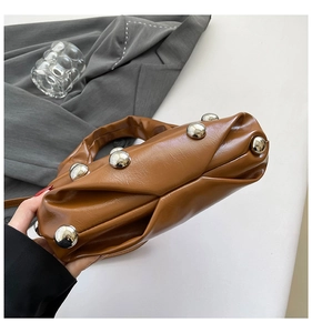 Détail du sac plissé en cuir PU marron avec des rivets argentés et une poignée
