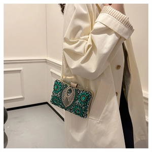 Detail of emerald green rhinestone evening bag with intricate floral gem patterns