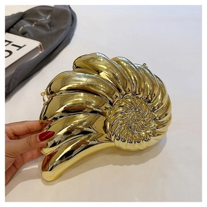 Détail d'une pochette nautile dorée montrant la texture polie et la spirale métallique