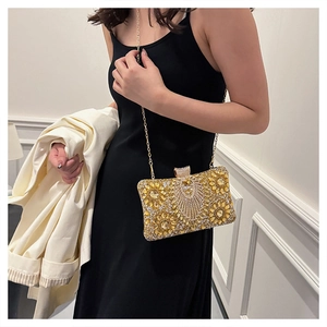 Close-up of sparkling golden rhinestone evening clutch with elegant chain strap