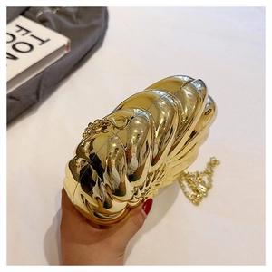 Vue détaillée de la pochette dorée brillante en forme de coquille à texture radiale
