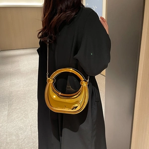 Sac croissant en acrylique doré avec poignée anneau et bandoulière sur mannequin