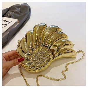 Détail de la texture en coquillage en spirale et du fini miroir doré brillant de la pochette