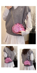 Détail macro du sac à chaîne rose métallisé en forme de nautile avec finition miroir