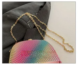 Macro shot of colorful rhinestone rainbow evening bag with golden metal chain strap