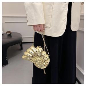 Détail du sac de soirée doré en forme de coquillage avec texture spirale et chaîne