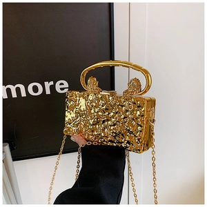 Détail de la pochette dorée avec texture craquelée et poignées à tête de lion