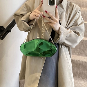 Metallic green acrylic stone clutch bag with gold chain strap in mirror selfie shot