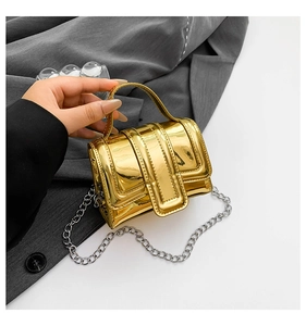 Macro detail of a mini gold mirror metallic flap bag with a silver chain shoulder strap