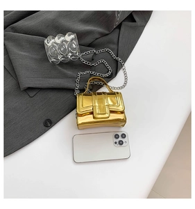 Detail view of mini gold mirror tote bag with metallic chain on professional display