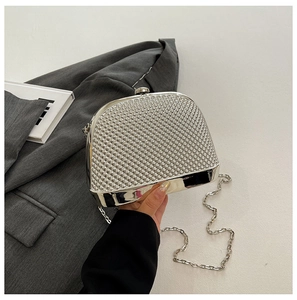 Detail of silver shell evening bag with textured surface and metallic clasp