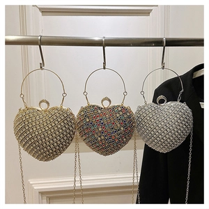 Three luxury heart-shaped rhinestone evening bags in gold, silver, and colorful crystal