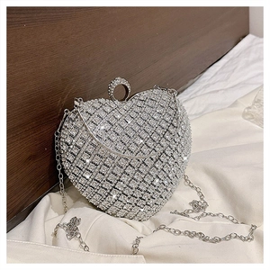 Macro shot of silver heart-shaped evening bag with sparkling rhinestones and chain