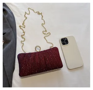 Burgundy glitter evening clutch size comparison with a smartphone and gold chain strap