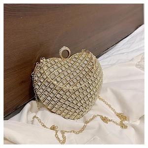 Macro detail of heart-shaped evening bag with sparkling rhinestones and gold handle