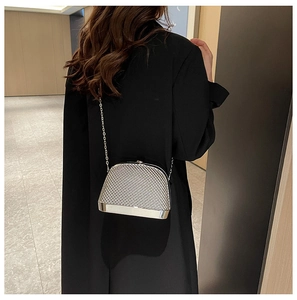 Chic silver metallic shell bag with chain strap shown on a model in a black blazer