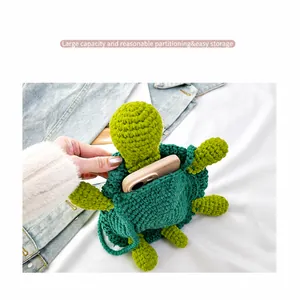 Detail of green knitted turtle bag showing storage capacity for a smartphone