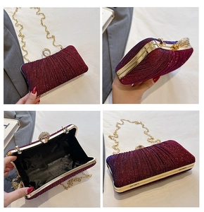 Macro view of wine red sequin evening clutch featuring rhinestone ring clasp and gold chain