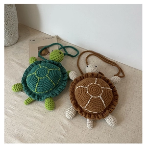 Macro detail of hand-knitted turtle crossbody bag showing crochet texture and stitching