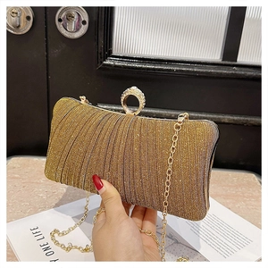 Detail of the golden glitter evening clutch bag with crystal ring handle and chain