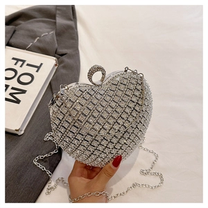 Detail of silver heart evening bag with sparkling rhinestones and metal ring handle